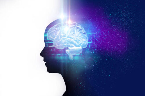 picture of the brain, glowing light blue, against the dark navy blue silhouette of a person dividing the picture in half, white and galaxy blue